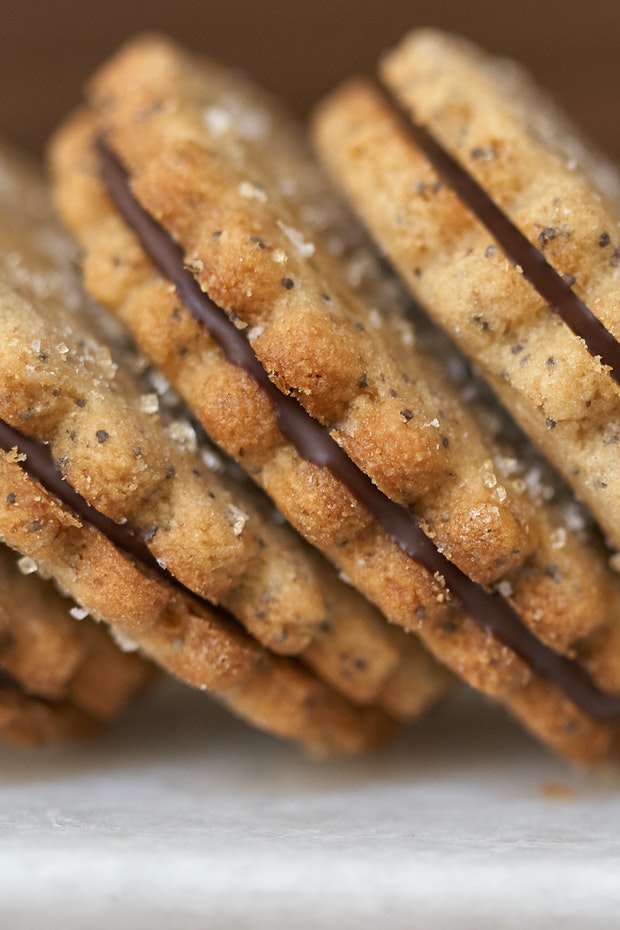 side view of a stack of sandwich cookies each filled with chocolate