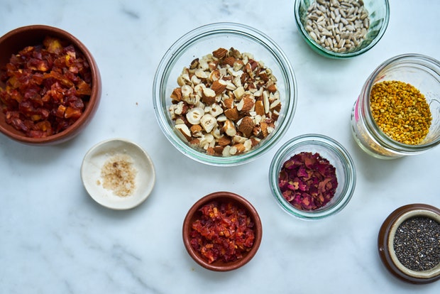 a range of topping ingredients including rose petals, dried plums, almonds, chia seeds
