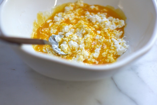 egg yolks and cottage cheese in a white mixing bowl